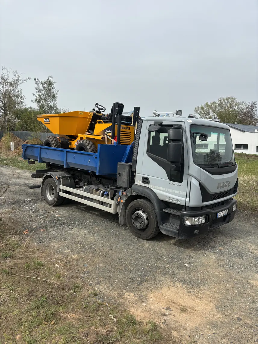Iveco Eurocargo přepravuje žlutý dumper